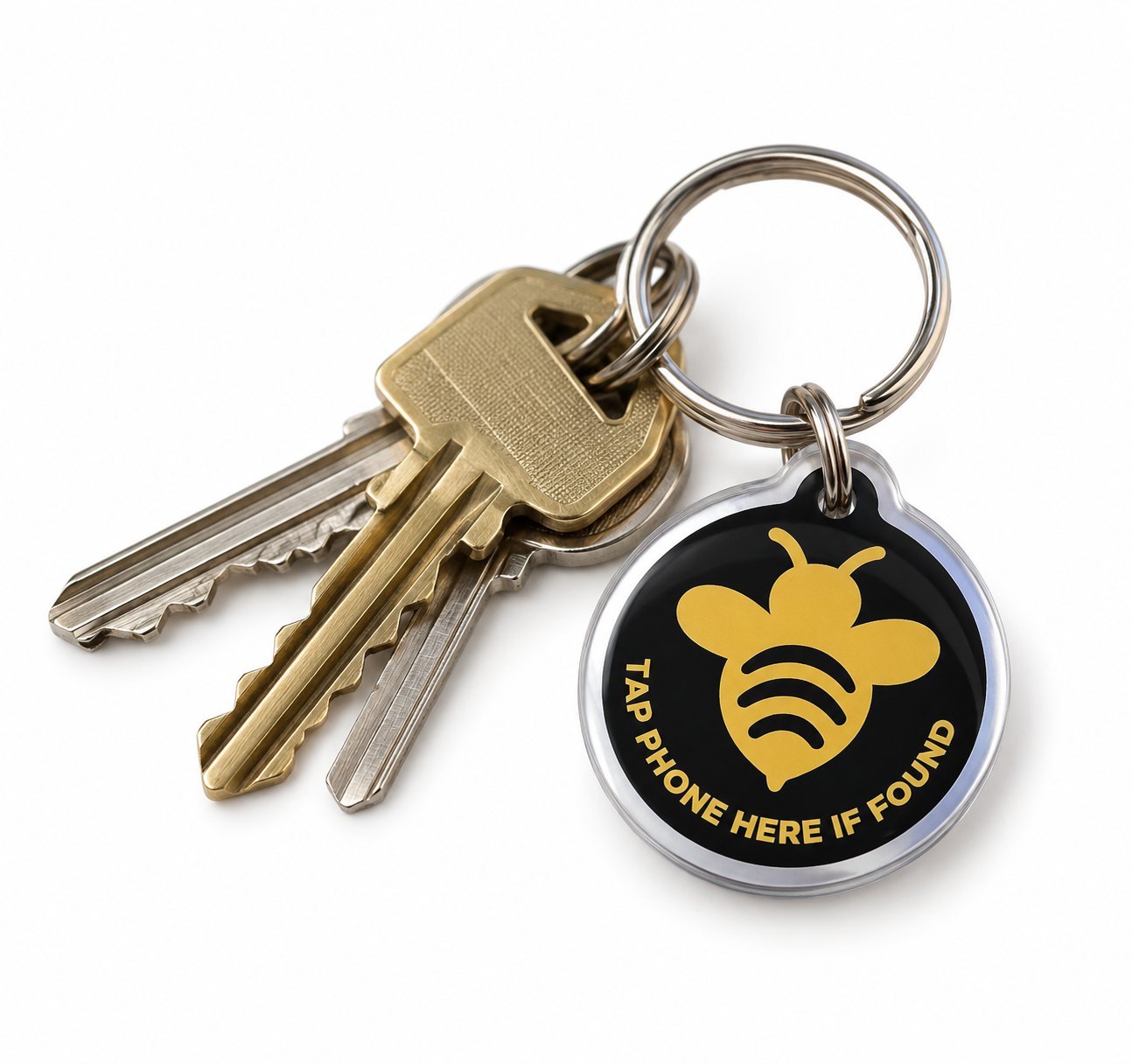 A Tagaby keychain on a ring of keys, reading Tap phone here if found